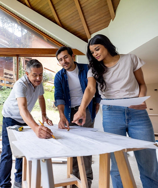 Couple with contractor discussing renovation or construction plans for their home