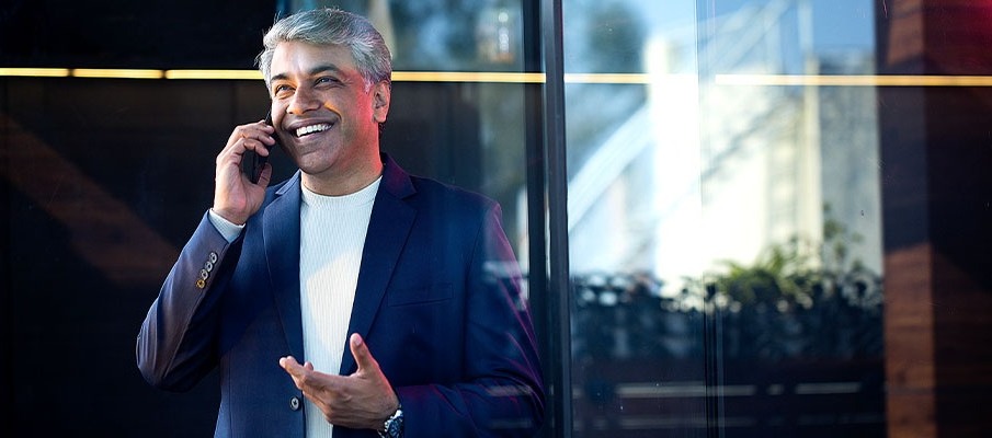 Middle-Aged Businessman Outside on Phone Smiling