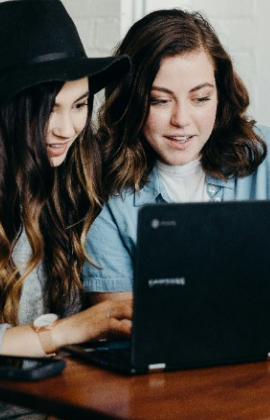 Two young woman using a laptop