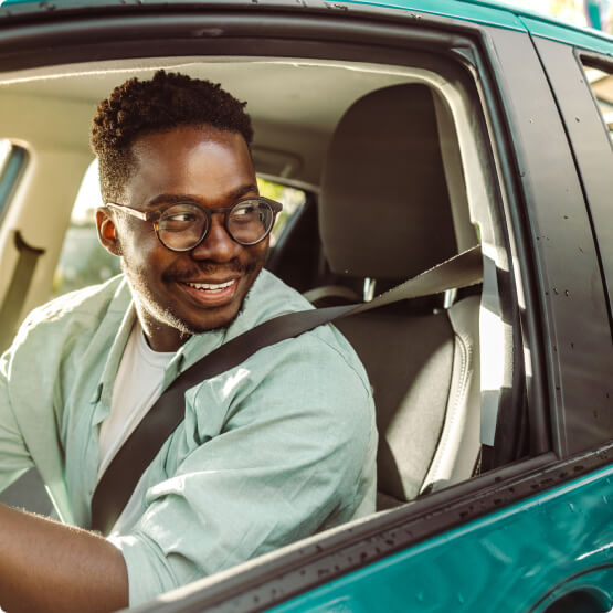 Man smiling in new car 
