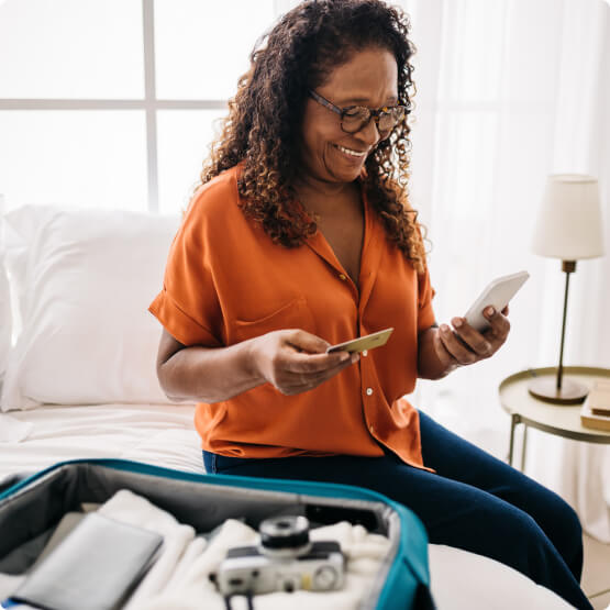 Woman holding mobile phone and debit/credit card