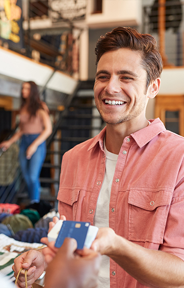 man making contactless payment at clothing store