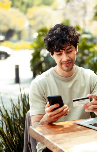 Man outside with debit/credit card and mobile phone 