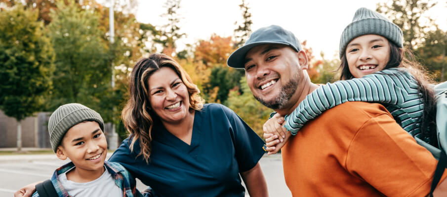 Family of four smiling at camera