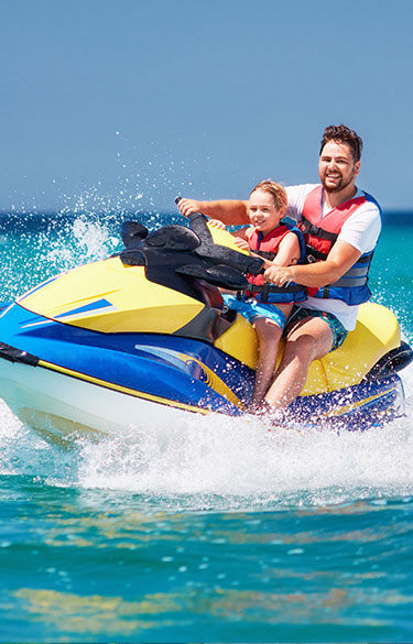 Father and son riding on Jet-ski.