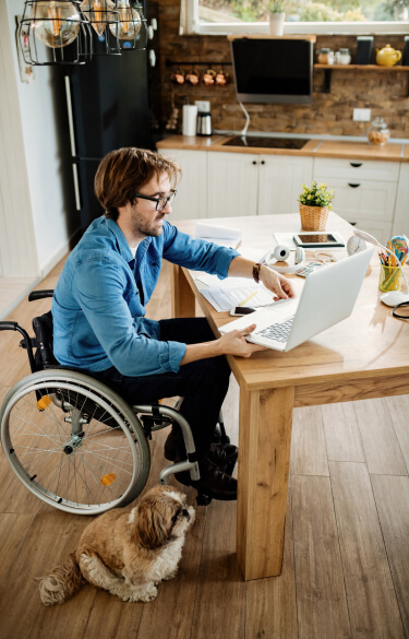 man in wheelchair using a laptop