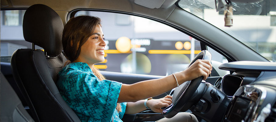 Young woman driving a new car.