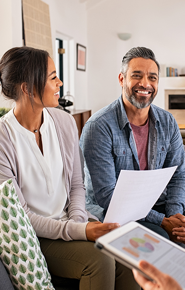 couple receiving financial advice smiling and holding a sheet of paper