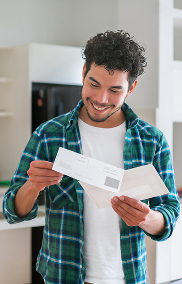 Man looking at mail smiling