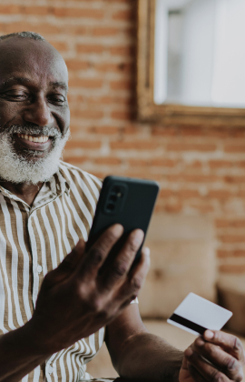 Mature man with mobile phone and debit/credit card