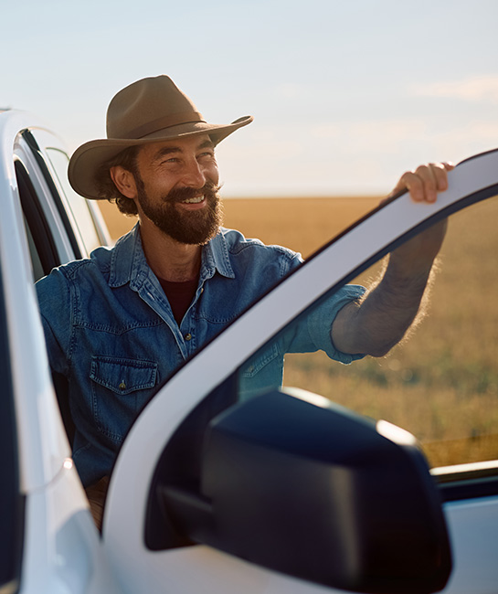 Cowboy smiling in field by his new truck