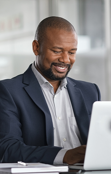 Man smiling in his office using a computer